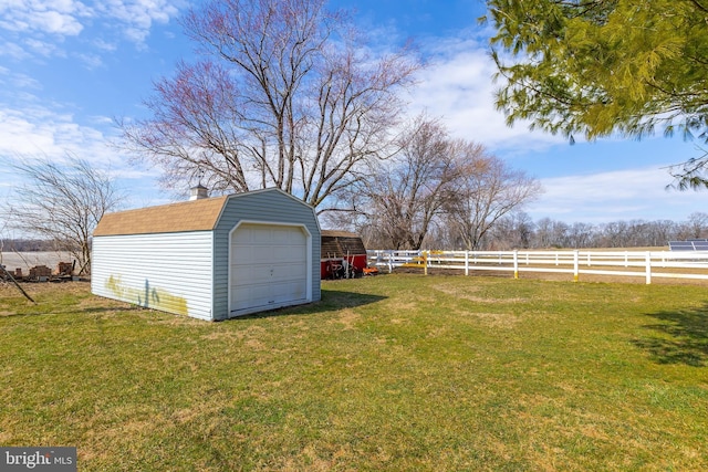 view of yard featuring a detached garage, a storage unit, fence, and an outdoor structure