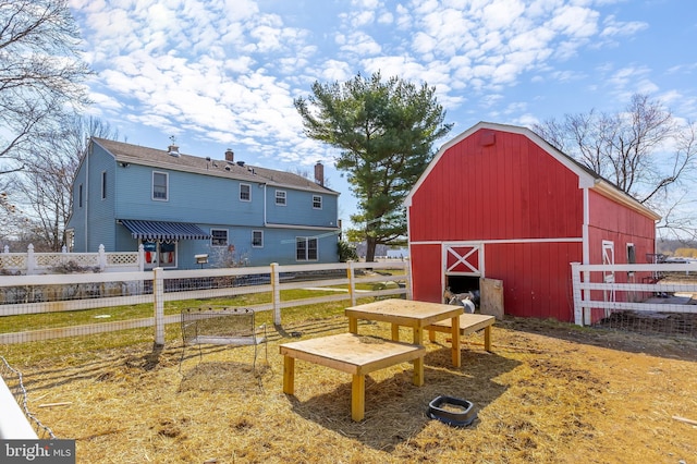 exterior space featuring an outbuilding, a barn, and fence