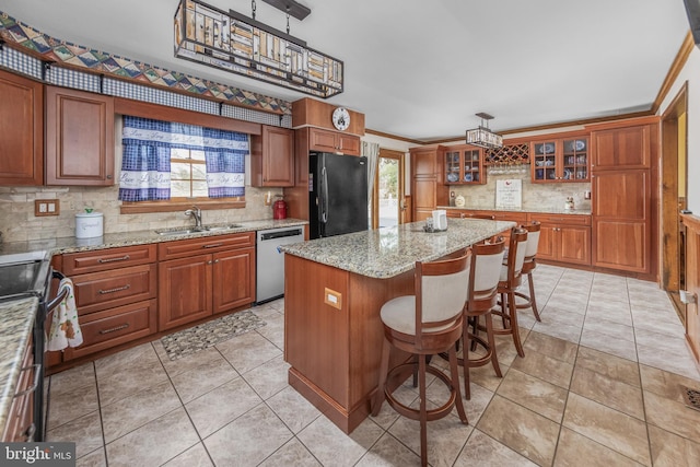 kitchen featuring brown cabinetry, a kitchen island, freestanding refrigerator, and stainless steel dishwasher