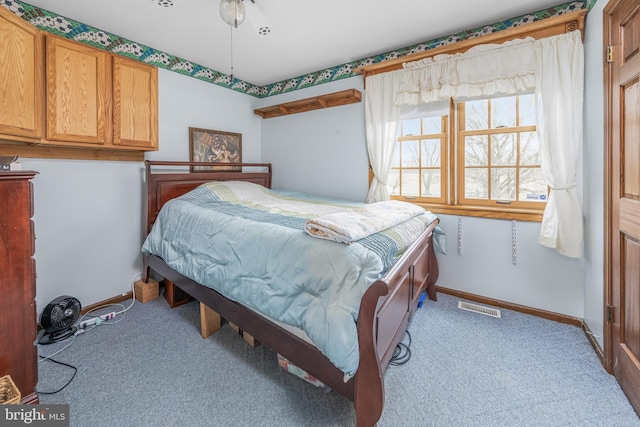 bedroom with visible vents, light carpet, and baseboards