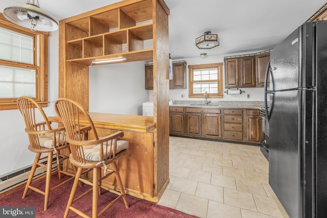 kitchen featuring open shelves, light tile patterned flooring, freestanding refrigerator, a sink, and stove