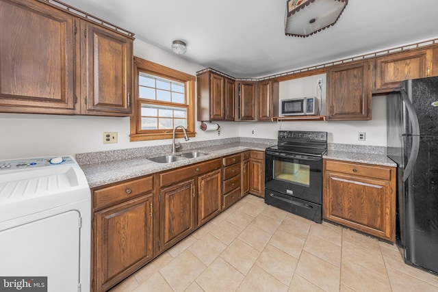 kitchen featuring black appliances, a sink, light countertops, light tile patterned floors, and washer / dryer