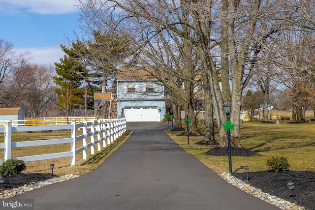 view of front of property with a front lawn, a garage, and a fenced front yard