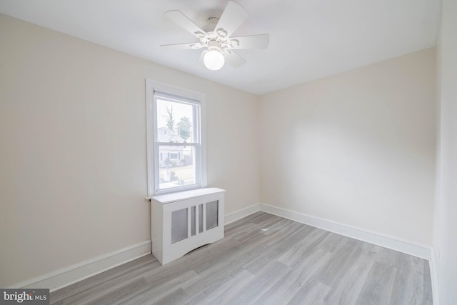 empty room with light wood-style flooring, baseboards, and a ceiling fan