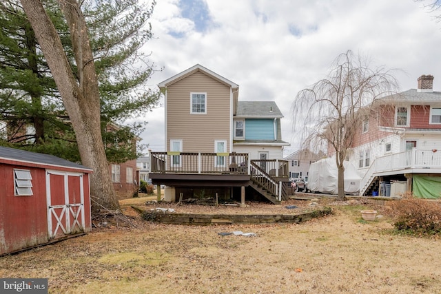 back of property with a storage shed, a wooden deck, stairway, and an outdoor structure