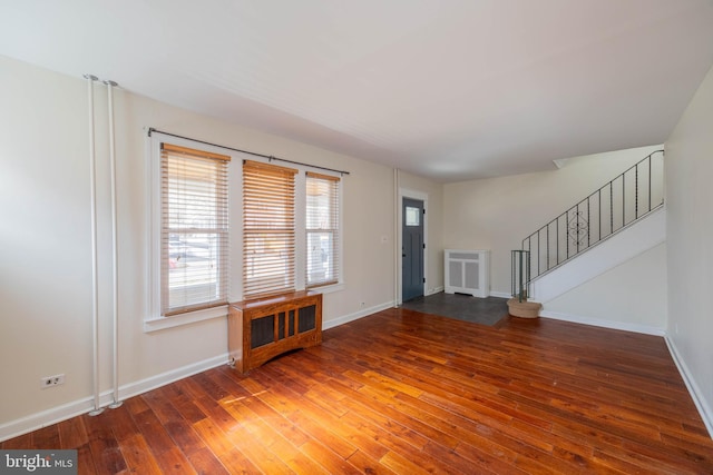 interior space with radiator, wood-type flooring, stairs, and baseboards