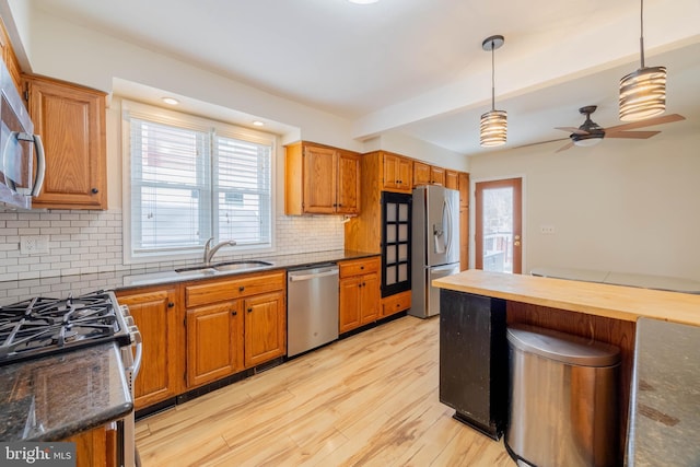 kitchen with light wood-style floors, plenty of natural light, stainless steel appliances, and a sink