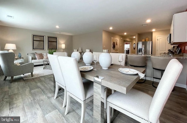 dining space with baseboards, visible vents, wood finished floors, and recessed lighting