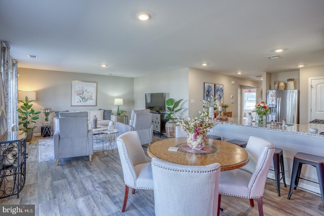 dining space featuring visible vents, wood finished floors, and recessed lighting