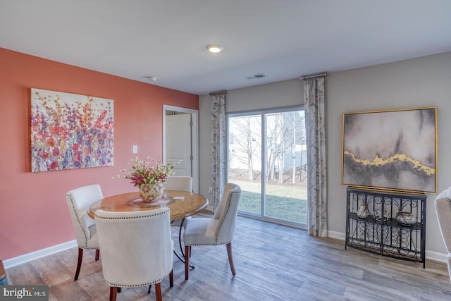 dining room with baseboards, visible vents, and wood finished floors