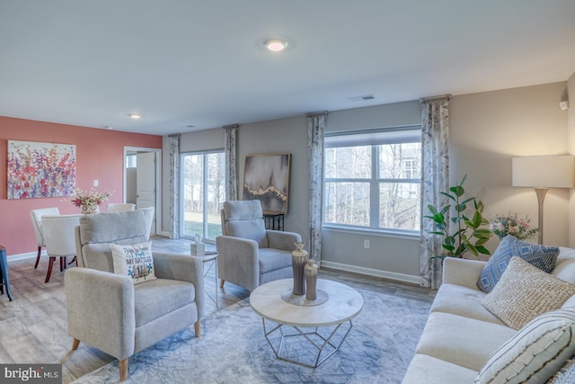 living room with wood finished floors, visible vents, and baseboards