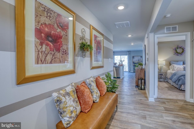 corridor featuring recessed lighting, visible vents, baseboards, and wood finished floors