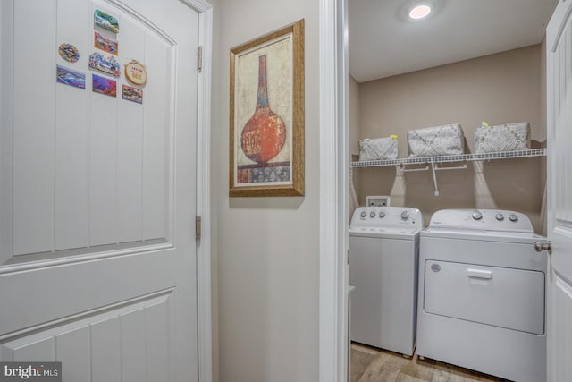 washroom with light wood-style floors, laundry area, and washing machine and clothes dryer