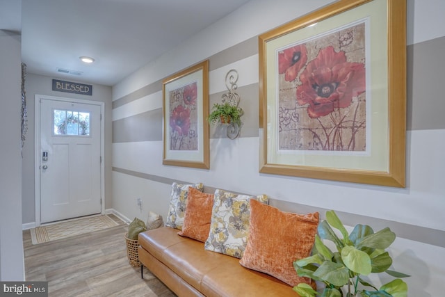 foyer with baseboards, visible vents, and wood finished floors