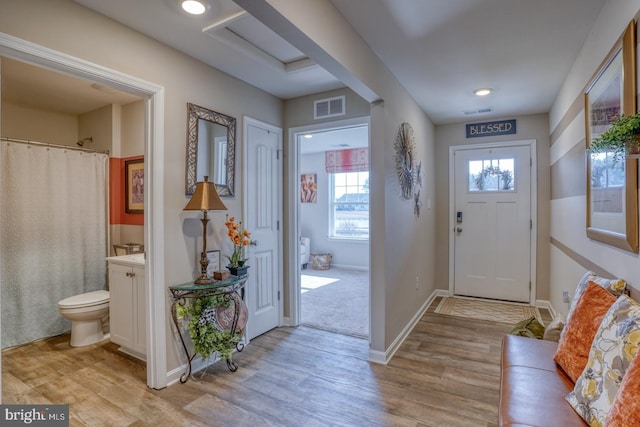 entrance foyer with light wood-style floors, visible vents, and baseboards