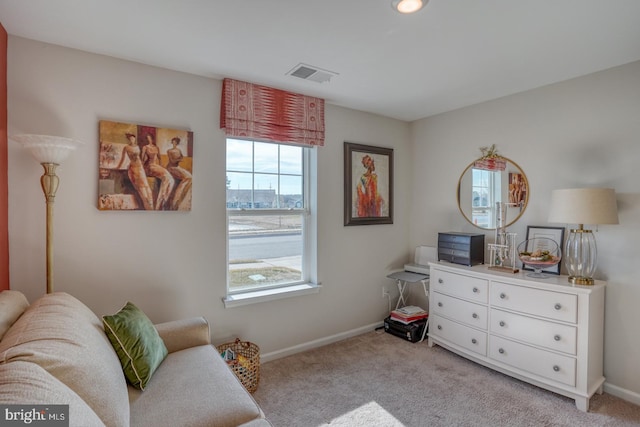 sitting room featuring light colored carpet, visible vents, and baseboards