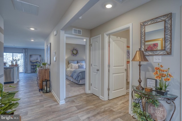 corridor featuring recessed lighting, visible vents, light wood-style flooring, and baseboards