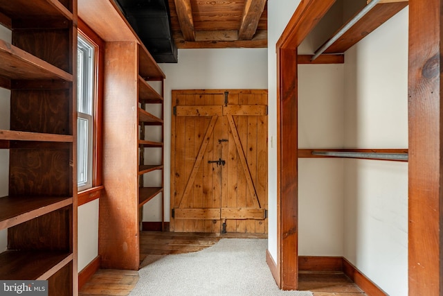 walk in closet with beamed ceiling