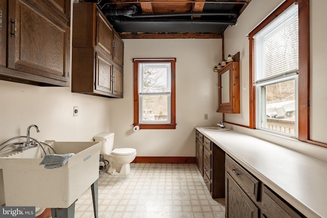 full bath with toilet, vanity, baseboards, and tile patterned floors