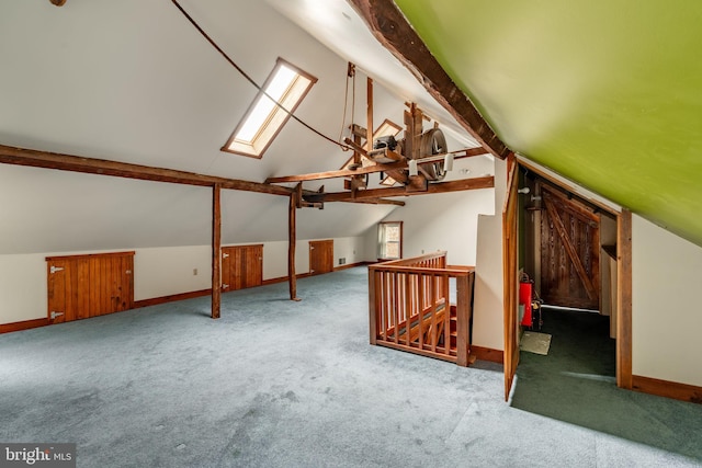 bonus room featuring carpet floors, lofted ceiling with skylight, and baseboards