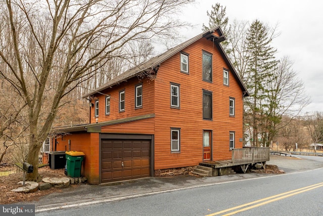 view of home's exterior featuring a garage and central AC unit