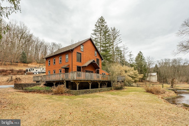 rear view of house featuring a deck and a yard