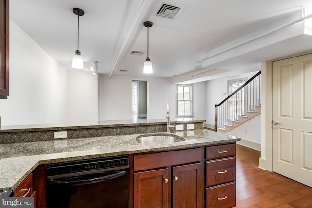 kitchen featuring dishwasher, a sink, visible vents, and pendant lighting