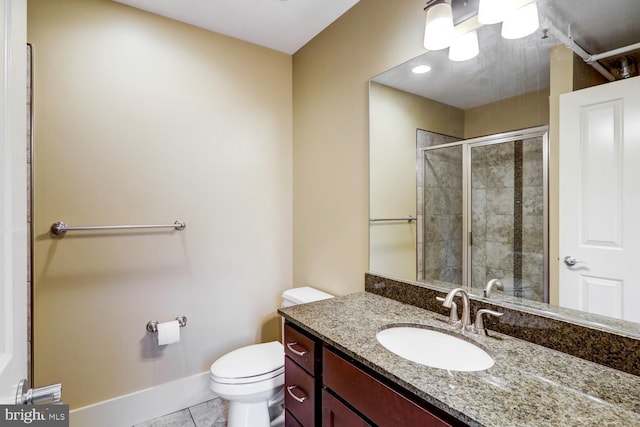 full bath featuring toilet, a stall shower, vanity, baseboards, and tile patterned floors