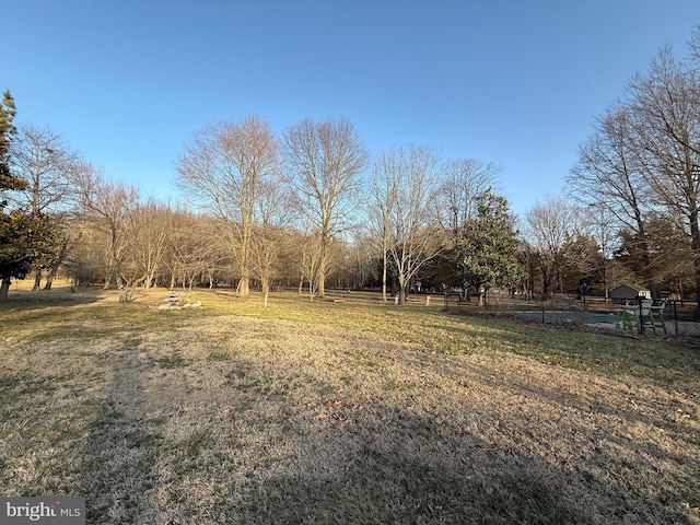 view of yard with fence and a rural view