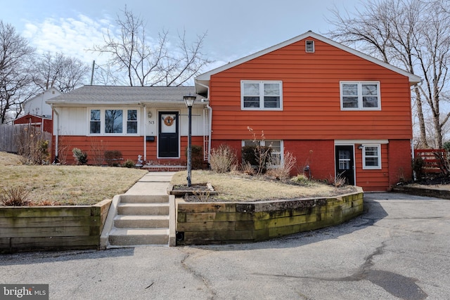 tri-level home featuring brick siding and driveway