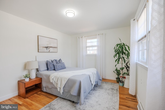 bedroom featuring baseboards and light wood finished floors