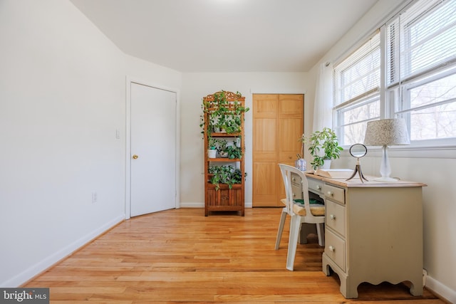 home office with light wood-type flooring and baseboards