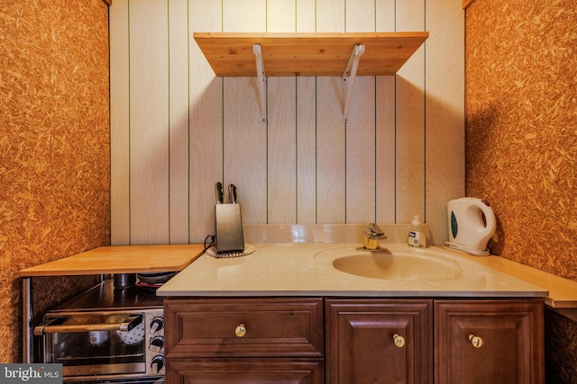 bathroom with vanity and wallpapered walls