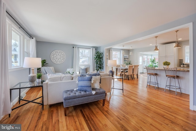 living area with light wood-style flooring and baseboards