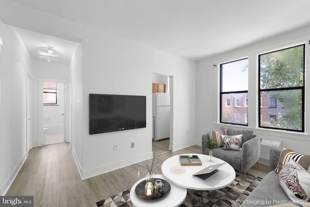 living area featuring light wood-style floors and baseboards