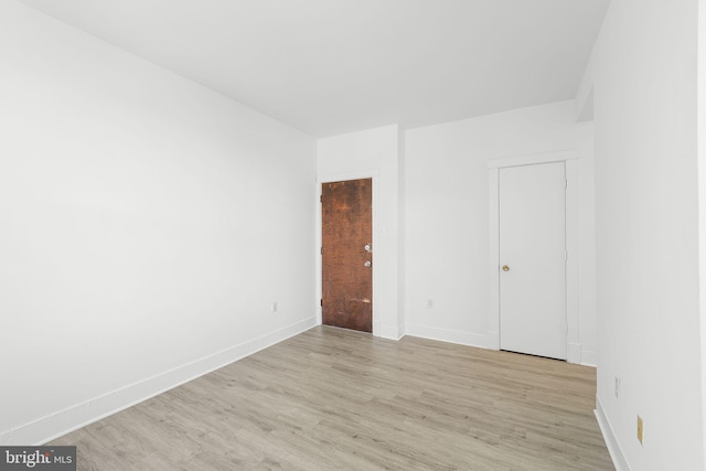 spare room featuring light wood-style flooring and baseboards