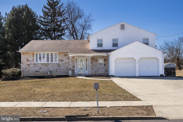 view of front facade with covered porch, a garage, driveway, stone siding, and a front yard