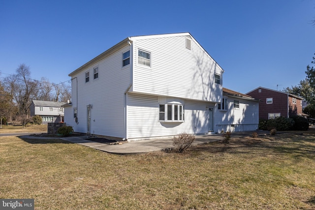 rear view of house featuring a patio and a yard