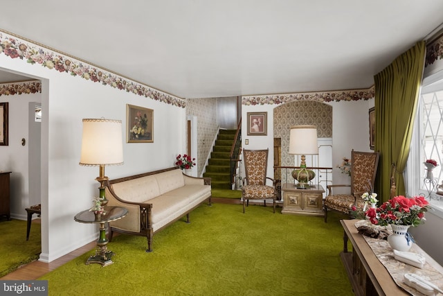 sitting room with wallpapered walls, stairs, and baseboards