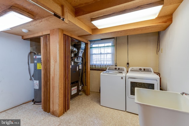 clothes washing area with laundry area, light floors, a sink, and independent washer and dryer