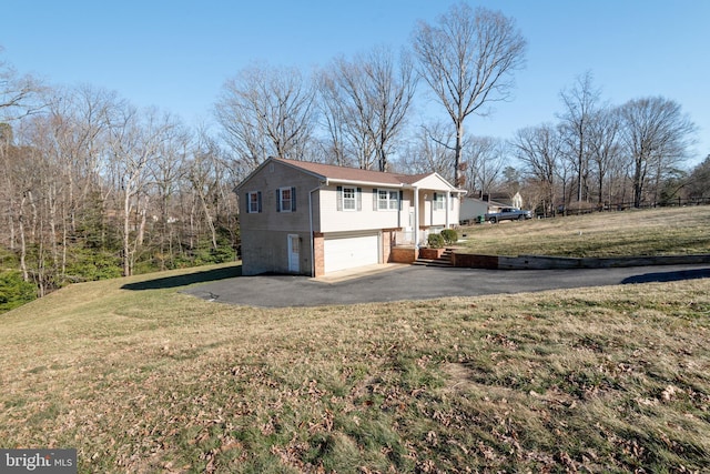 view of side of property with driveway, a yard, an attached garage, and brick siding