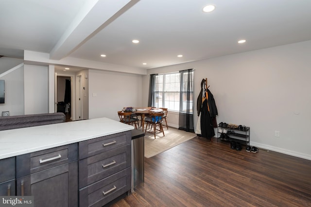 kitchen with light stone countertops, baseboards, dark wood-type flooring, and recessed lighting