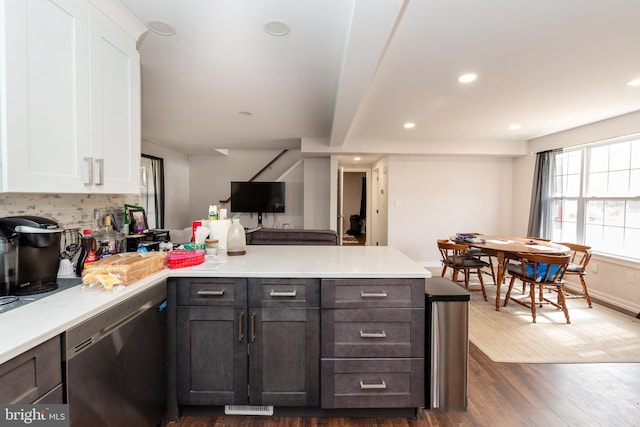 kitchen featuring dark wood-type flooring, white cabinetry, dishwasher, and a peninsula