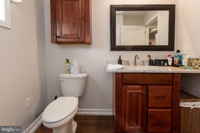 bathroom featuring vanity, wood finished floors, toilet, and baseboards