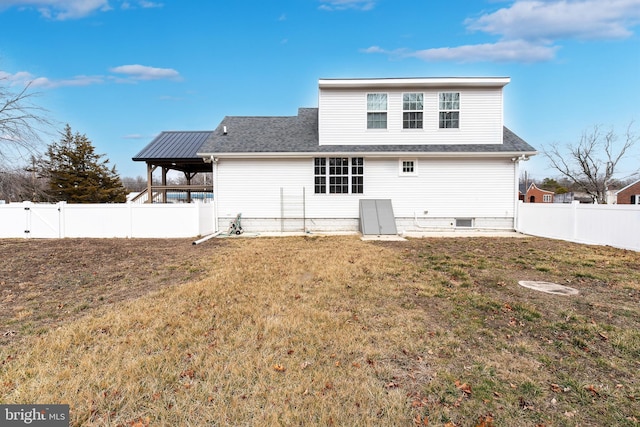 back of property featuring roof with shingles, a lawn, a fenced backyard, and a gate