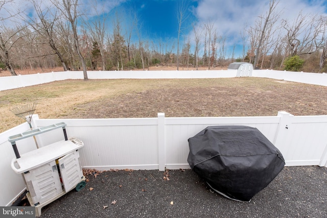 view of yard with an outbuilding, a storage shed, and a fenced backyard