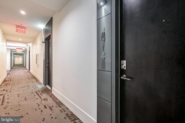 hallway with carpet flooring and baseboards