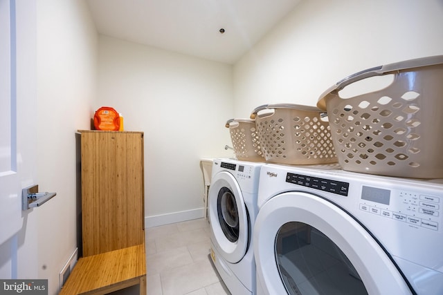 washroom with laundry area, baseboards, separate washer and dryer, and light tile patterned flooring