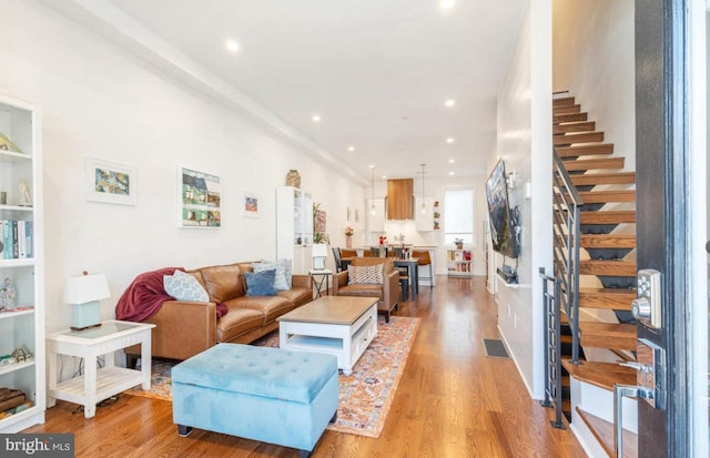 living room with light wood-style floors, recessed lighting, visible vents, and stairway