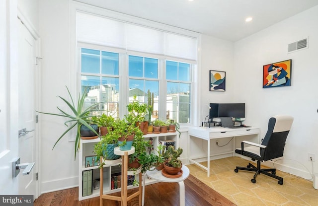 office space featuring visible vents, baseboards, and wood finished floors